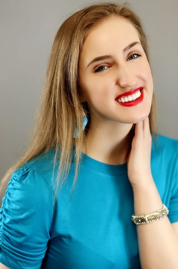 Portrait of the author smiling in a blue shirt